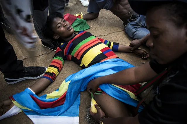 A Congolese protester lies on the ground after police opened fire wth rubber bullets whilst they protest outside the Democratic Republic of the Congo's Embassy in defiance of their President, Joseph Kabila on December 20, 2016 in Pretoria. The United Nations voiced alarm over a wave of arrests in the Democratic Republic of Congo, where tensions were running high after President Joseph Kabila's term in office expired. Tuesday marked the end of the second and constitutionally-mandated final term for the 45-year-old, who inherited the presidency after the 2001 assassination of his father. But he is now refusing to leave the job that he began without much fanfare. (Photo by John Wessels/AFP Photo)