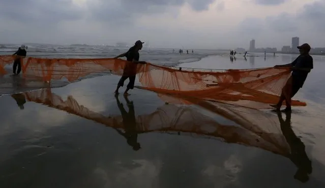 Pakistani fishermen pull their net out of the sea onto the beach in Karachi, Pakistan, Saturday, May 29, 2021. (Photo by Fareed Khan/AP Photo)