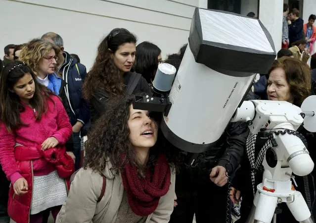 Amateur astronomers and students use a telescope to watch a partial eclipse of the sun in Athens, March 20, 2015. (Photo by Yannis Behrakis/Reuters)