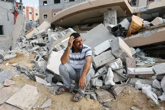 A Palestinian man reacts next to the ruins of a house destroyed in Israeli strikes in Khan Younis, in the southern Gaza Strip on October 8, 2023. (Photo by Ibraheem Abu Mustafa/Reuters)