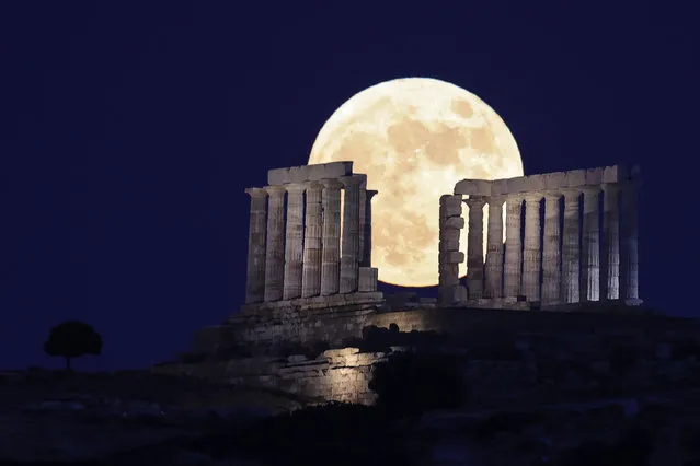 Full moon, also known as the Strawberry Moon, rises behind Temple of Poseidon, near capital city Athens, in Cape Sounio, Greece on June 24, 2021. (Photo by Ayhan Mehmet/Anadolu Agency via Getty Images)