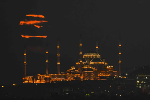 A super moon rises behind Camlica mosque in Istanbul, Turkey, Friday, September 29, 2023. (Photo by Khalil Hamra/AP Photo)