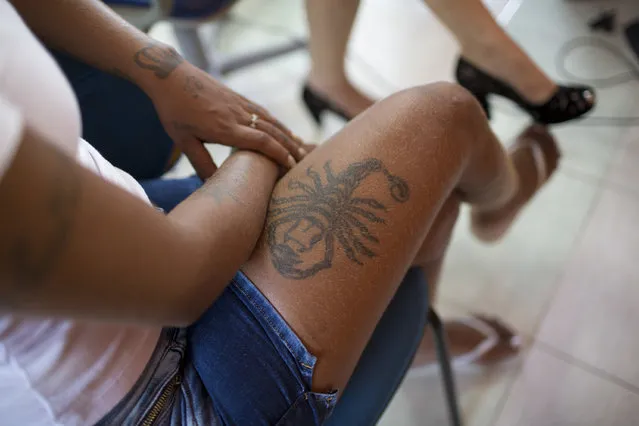 An inmate with a scorpion tattooed on her thigh waits to have her hair styled, before the start of the 13th annual Miss Talavera Bruce beauty pageant at the penitentiary the pageant is named for, in Rio de Janeiro, Brazil, Tuesday, December 4, 2018. Hairdressers and makeup artists volunteer their time to ready the contestants who are judged on their beauty, appeal and attitude. (Photo by Silvia Izquierdo/AP Photo)