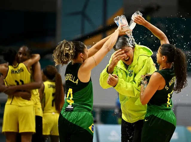 Brazil's Carina Dos Santos and Gabriella Darrigo celebrate winning the women's basketball final with Brazil coach Joao Almeida Camargo at the Pan Am Games in Santiago, Chile on October 30, 2023. (Photo by Dylan Martinez/Reuters)