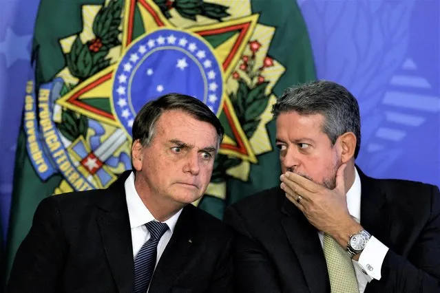 Brazil’s President Jair Bolsonaro reacts with Brazil's Lower House President Arthur Lira during a ceremony to sanction a bill that establishes salaries for nurses, in Brasilia, Brazil on August 4, 2022. (Photo by Ueslei Marcelino/Reuters)