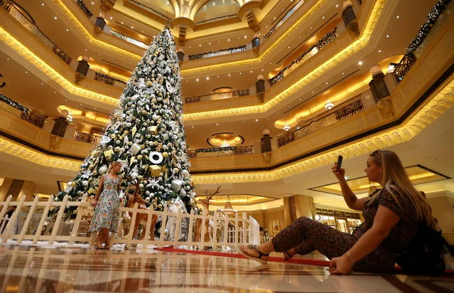 Tourists take picture with the Christmas tree of the Emirates Palace luxury hotel in Abu Dhabi, United Arab Emirates, 25 December 2018. Millions of Catholic Christians around the world celebrate Christmas on 25 December. (Photo by Ali Haider/EPA/EFE)