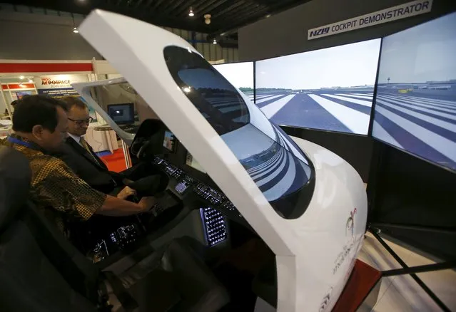 A visitor tries the PT Dirgantara Indonesia N-219 cockpit simulator at their booth during the Singapore Airshow at Changi Exhibition Center February 17, 2016. (Photo by Edgar Su/Reuters)