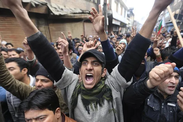 Supporters of Jammu Kashmir Liberation Front (JKLF) chairman Yasin Malik shout slogans during a memorial service to mark the anniversary of an alleged massacre in Srinagar, India, Tuesday, January 21, 2014. People in the valley allege that Indian security forces opened indiscriminate fire on thousands of peaceful demonstrators near Gaw Kadal in Srinagar, killing more than 50 people 24 years ago. (Photo by Dar Yasin/AP Photo)