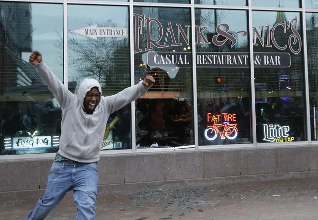A protestor reacts after breaking a restaurant window after a rally for Freddie Gray, Saturday, April 25, 2015, in Baltimore. (Photo by Patrick Semansky/AP Photo)