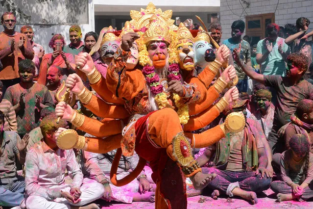 An Indian artist dressed as Lord Hanuman performs traditional folk dance during Holi festival celebrations at a temple in Amritsar on March 21, 2019. Holi, the popular Hindu spring festival of colours is observed in India and across countries at the end of the winter season on the last full moon of the lunar month. (Photo by Narinder Nanu/AFP Photo)