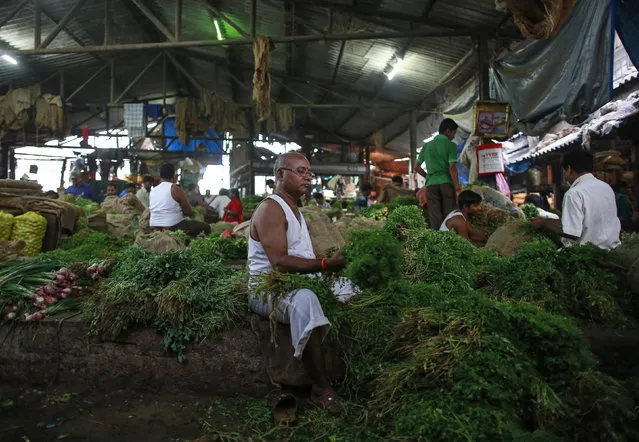 A vendor sorts coriander at his stall at a wholesale fruit and vegetable market in Mumbai, India, March 14, 2016. India's wholesale prices fell for a 16th straight month in February, declining an annual 0.91 percent, driven down by tumbling oil prices, government data showed on Monday. (Photo by Danish Siddiqui/Reuters)
