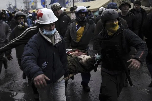 Anti-government protesters carry an injured man on a stretcher after clashes with riot police in Independence Square in Kiev February 20, 2014. (Photo by Maks Levin/Reuters)