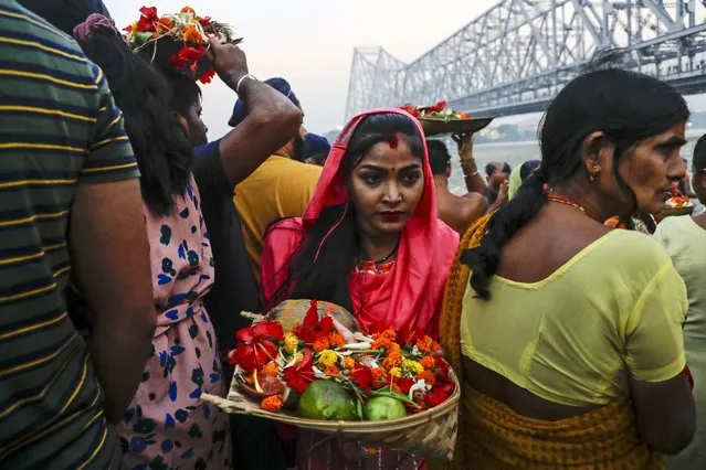 Devotees gather on the banks of Hooghly River early morning during Chhath festival, in Kolkata, India, Thursday, November 11, 2021. During Chhath, an ancient Hindu festival, rituals are performed to thank the sun god for sustaining life on earth. (Photo by Bikas Das/AP Photo)
