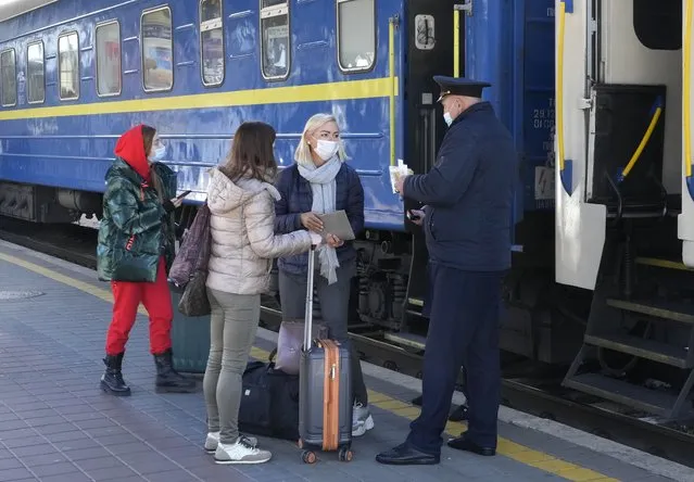 A train conductor checks the Covid Certificate of passengers, at a train station in Kyiv, Ukraine, Ukraine, Tuesday, October 26, 2021. Coronavirus infections and deaths in Ukraine have surged to all-time highs amid a laggard pace of vaccination, which is one of the lowest in Europe. (Photo by Efrem Lukatsky/AP Photo)