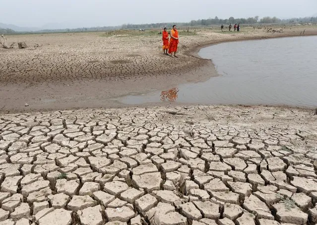 A picture made available on 30 March 2016 shows Thai Buddhist monks view an almost dried up Mae Chang reservoir in Lampang province, northern Thailand, 12 March 2016. Thailand is facing water shortage caused by the worst drought in decades due to El Nino phenomenon combined with seasonal hot weather which have critically hit water storage as the water levels in the country's biggest dams are lower than 10 percent. (Photo by Rungroj Yongrit/EPA)