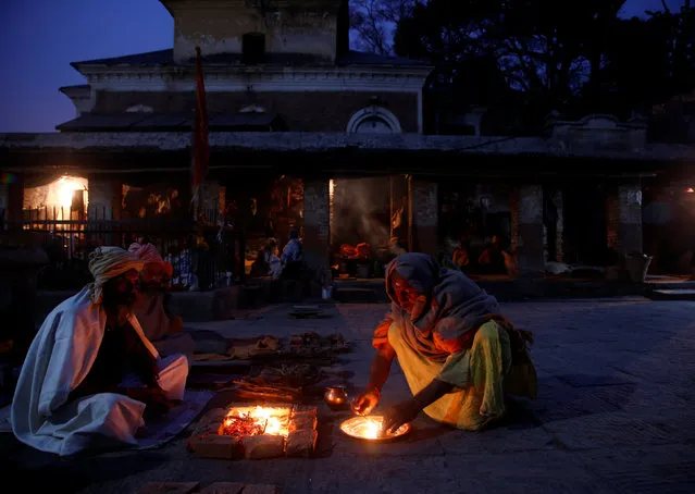 Hindu holy men, or sadhus, sit beside a fire at the premises of Pashupatinath Temple, ahead of the Shivaratri festival, in Kathmandu, Nepal February 20, 2017. (Photo by Navesh Chitrakar/Reuters)