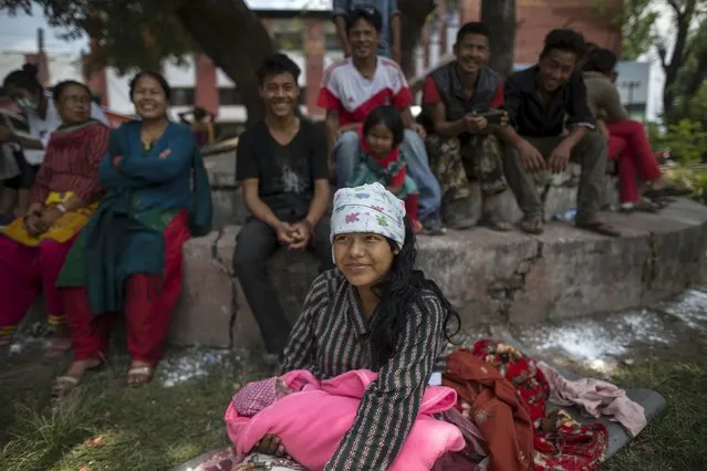 Maya Tamang, 20, holds her one-day-old daughter as she sits surrounded by family members at a makeshift shelter outside Bhaktapur hospital in Bhaktapur, Nepal, May 13, 2015. (Photo by Athit Perawongmetha/Reuters)