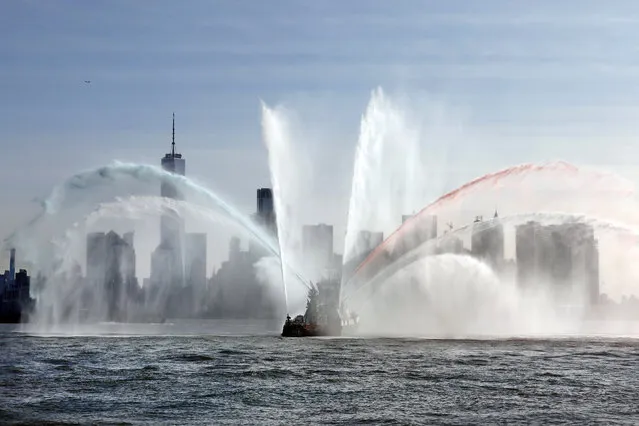 The Fire Department of New York “Firefighter II” sprays water while participating in Fleet Week New York, in New York harbor, Wednesday, May 22, 2019. (Photo by Richard Drew/AP Photo)