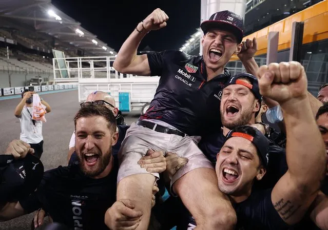 Race winner and 2021 F1 World Drivers Champion Max Verstappen of Netherlands and Red Bull Racing celebrates with his team after the F1 Grand Prix of Abu Dhabi at Yas Marina Circuit on December 12, 2021 in Abu Dhabi, United Arab Emirates. (Photo by Lars Baron/Getty Images)