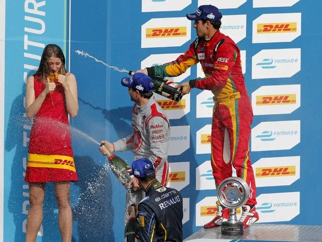 First placed Audi Sport ABT driver Lucas Di Grassi (R) of Brazil, second placed Dragon Racing driver Jerome d'Ambrosio (C) of Belgium and third placed E.Dams Renault driver Sebastien Buemi of Switzerland spray champagne on the podium after the Formula E Championship race at the former Tempelhof airport in Berlin, Germany, May 23, 2015. (Photo by Fabrizio Bensch/Reuters)