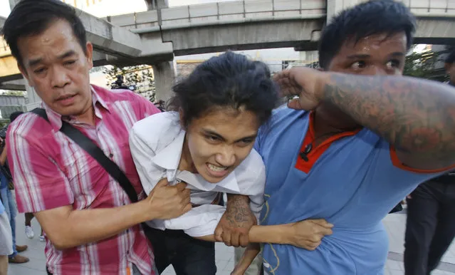 Police officers drag a student protester in Bangkok, Thailand Friday, May 22, 2015. (Photo by Sakchai Lalit/AP Photo)