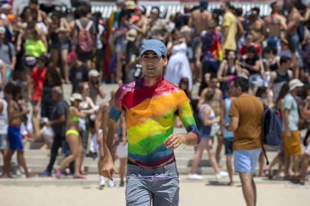 An Israeli has the rainbow colours painted across his torso as he runs down thew beach towards the Mediterranean Sea during the Gay Pride parade, in Tel Aviv, Israel, 14 June 2019. Israel is hosting Gay Pride parades in 12 different cities in the month of June, making it one of the Mediterranean Sea's most popular vacation destination for the LGBT communities. (Photo by Jim Hollander/EPA/EFE)