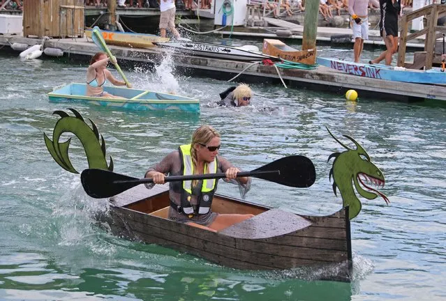 Contestants in the Schooner Wharf Minimal Regatta paddle their entries in Key West Florida in this May 24, 2015 handout photo. The rules of the wacky Memorial Day Weekend event required each team to build a boat out of a single sheet of 4-by-8-foot plywood, two 8-foot-long two-by-fours, a roll of duct tape, a pound of fasteners and epoxy paint. (Photo by Rob O'Neal/Reuters/Florida Keys News Bureau)