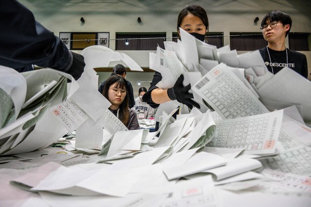 Election officials sort through ballots at a counting station in Seoul on April 10, 2024, after voting in the parliamentary elections was closed. (Photo by Anthony Wallace/AFP Photo)