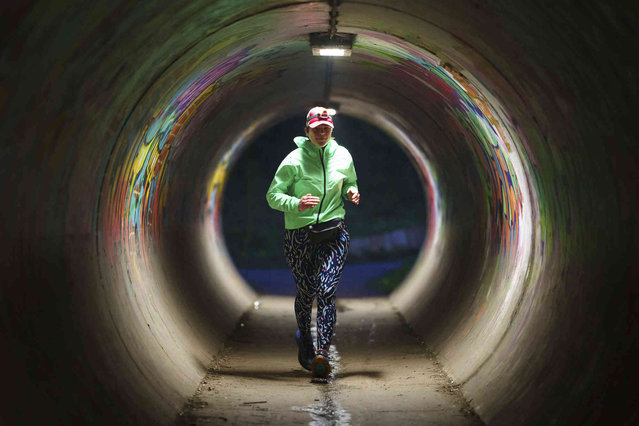 Ultra runner Helen Ryvar runs through an underpass in Wrexham during running a half marathon in Wrexham, Wales, Wednesday, March 20, 2024. Helen who took up running in 2020 just before lockdown completes her daily half marathon early so as to fit in a full time job and being a single parent to 3 children. (Photo by Jon Super/AP Photo)