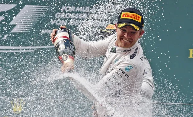 Mercedes driver Nico Rosberg of Germany sprays champagne as he celebrates his victory in the Formula One Grand Prix race, at the Red Bull Ring in Spielberg, southern Austria, Sunday, June 21, 2015. (AP Photo/Darko Bandic)