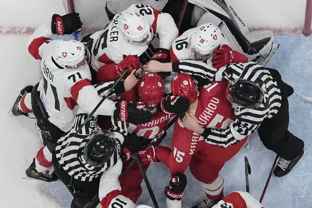 Russian Olympic Committee and Switzerland players fight as officials try to separate them during a preliminary round men's hockey game at the 2022 Winter Olympics, Wednesday, February 9, 2022, in Beijing. (Photo by Matt Slocum/AP Photo)