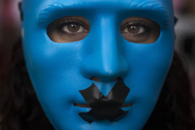 A protestor wears a mask with a gag as she marches against the Public Security Law in Madrid, Spain, Tuesday, June 30, 2015. Thousands of protesters railed Tuesday against a new Spanish public security law nicknamed the “gag law” before it went into effect at midnight, slamming it as legalized muzzling of free expression and the media. (Photo by Andres Kudacki/AP Photo)