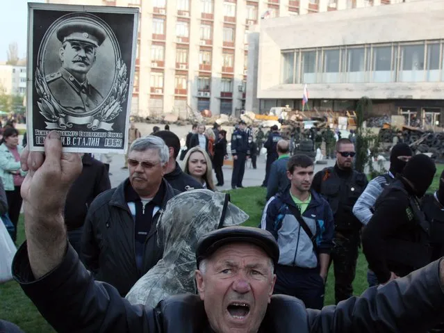 A pro-Russia activist holds a portrait of Stalin as he together with the others gather to prevent a planned campaigning visit of  presidential candidate Yulia Tymoshenko to the eastern Ukrainian city of Donetsk on April 22, 2014. The visit was cancelled. (Photo by Anatolii Stepanov/AFP Photo)