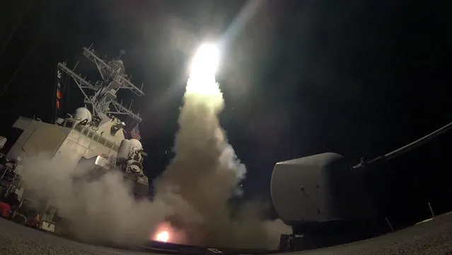 In this image provided by the U.S. Navy, the guided-missile destroyer USS Porter (DDG 78) launches a tomahawk land attack missile in the Mediterranean Sea, Friday, April 7, 2017. The United States blasted a Syrian air base with a barrage of cruise missiles in fiery retaliation for this week's gruesome chemical weapons attack against civilians. (Photo by Mass Communication Specialist 3rd Class Ford Williams/U.S. Navy via AP Photo)