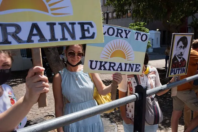 Protestors holding posters stand outside the South African Parliament as a show of support for the Ukrainian people, protesting against Russia's invasion into Ukraine, and calling for the South African government to condemn the action of the Russians, March 05, 2022, in Cape Town. (Photo by Rodger Bosch/AFP Photo)