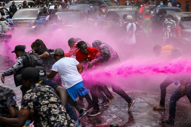 Protesters are pushed away by a water canon that was trying to disperse them as they took part in a demonstration against a controversial tax bill in the central business district in Nairobi, Kenya, 20 June 2024. Police have fired tear gas to disperse protesters who gathered near the parliament to demonstrate against planned tax hikes that many fear will worsen the cost-of-living crisis. (Photo by Daniel Irungu/EPA/EFE)