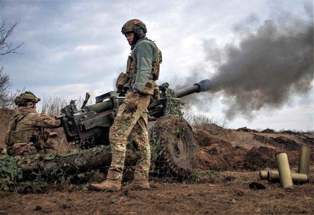 Ukrainian service members from a battalion, named of nom-de-guerre of their commander “Da Vinci”, Hero of Ukraine, who was killed in a fight against Russian troops, fire a howitzer M119 at a front line, amid Russia's attack on Ukraine, near the city of Bakhmut, Ukraine on March 10, 2023. (Photo by Oleksandr Ratushniak/Reuters)