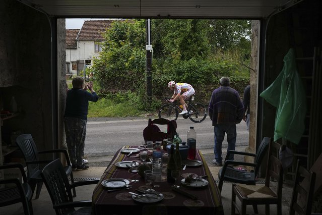 People get up from their table to watch Norway's Jonas Abrahamsen, wearing the best climber's dotted jersey, pass during the eighth stage of the Tour de France cycling race over 183.4 kilometers (114 miles) with start in Semur-en-Auxois and finish in Colombey-les-Deux-Eglises, France, Saturday, July 6, 2024. (Photo by Daniel Cole/AP Photo)