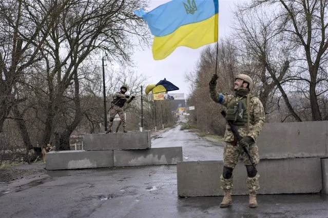 Ukrainian soldiers celebrate at a check point in Bucha, on the outskirts of Kyiv, Ukraine, Sunday, April 3, 2022. (Photo by Rodrigo Abd/AP Photo)