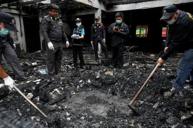 Forensic exports inspect a burnt building at the Pitakkiat Wittaya School in the northern province of Chiang Rai, Thailand, May 23, 2016. At least 18 girls aged from 5 to 12 were killed overnight in Thailand's northern province of Chiang Rai when a powerful blaze swept through a Christian school for girls from poor families. Some of those who survived had to tie cloth together to climb out of the window. (Photo by Athit Perawongmetha/Reuters)