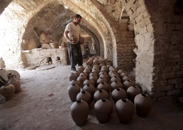 Iraqi potters work on clay pots at a workshop in Najaf, south of Baghdad, July 23, 2015. (Photo by Alaa Al-Marjani/Reuters)