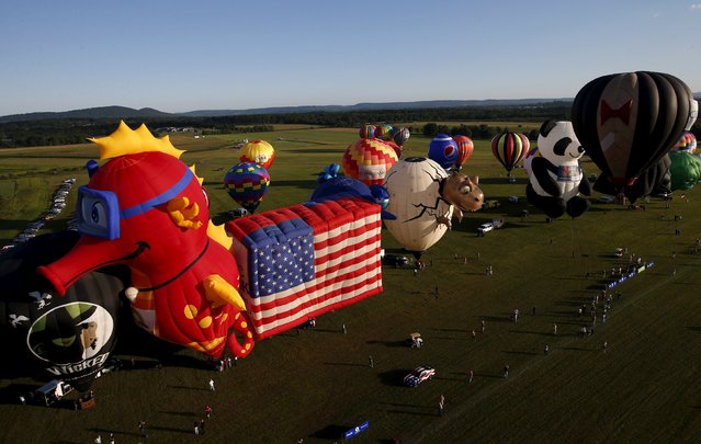 Hot air balloons in many shapes are seen from a flying balloon just after sunrise on day one of the 2015 New Jersey Festival of Ballooning in Readington, New Jersey, July 24, 2015. (Photo by Mike Segar/Reuters)