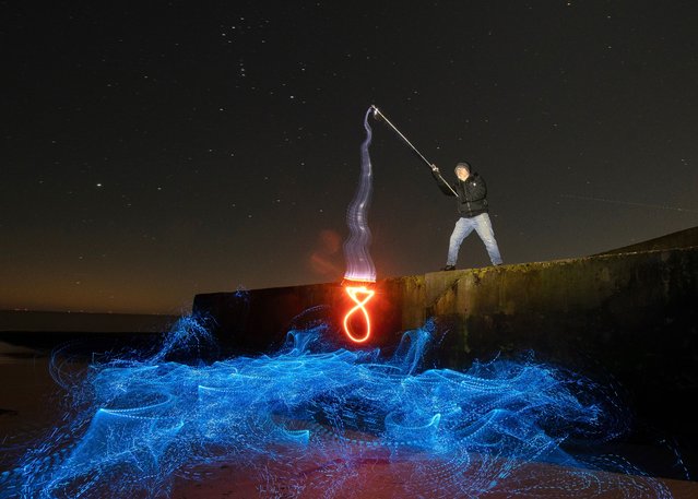 Kevin Jay and Nigel Cox painting with light coloured LED lights during a 54-second exposure on the beach at Frinton-on-Sea in Essex, UK on January 19, 2024. (Photo by Kevin Jay/Picture Exclusive)