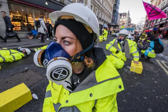 Extinction Rebellion protesters block Cranbourne Street, outside Leicester Square Station in London, England on December 9, 2019, to demand action on air pollution. The roadblock includes 25 breeze blocks glued to the road to symbolise the 25 Londoners who die each day as a result of air pollution and eight people are glued onto the blocks. Extinction Rebellion's 12 Days of Crisis to ensure the Climate and Ecological Emergency is at the top of the agenda this General Election. (Photo by Guy Bell/Rex Features/Shutterstock)