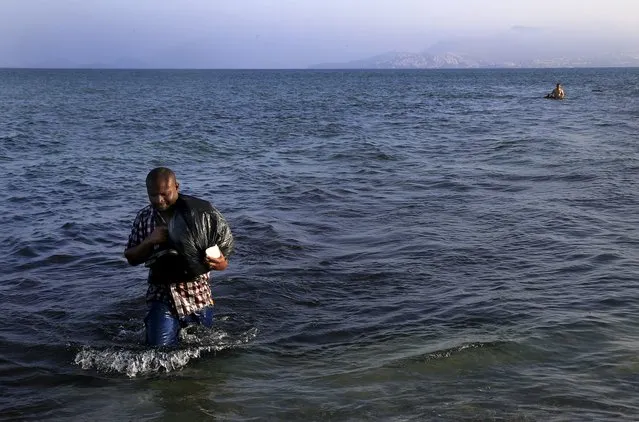 A migrant from Mali walks ashore on the Greek island of Kos after crossing a part of the Aegean Sea between Turkey and Greece, August 8, 2015. The U.N refugee agency, UNHCR, estimates that Greece has received more than 107,000 refugees and migrants this year, more than double its 43,500 intake of 2014. (Photo by Yannis Behrakis/Reuters)