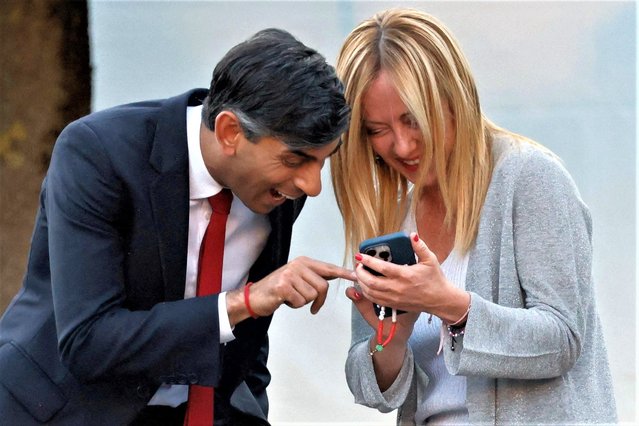 Britain's Prime Minister Rishi Sunak (L) and Italy's Prime Minister Giorgia Meloni react ahead of the social dinner during the NATO summit, at the Presidential Palace in Vilnius on July 11, 2023. NATO leaders will grapple with Ukraine's membership ambitions at their summit on July 11, 2023, their determination to face down Russia boosted by a breakthrough in Sweden's bid to join the alliance. (Photo by Ludovic Marin/Pool via AFP Photo)