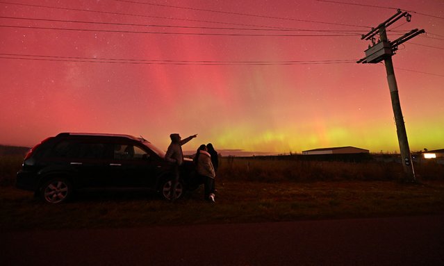 People look at the Aurora Australis, also known as the Southern Lights, in Rolleston outskirts of Christchurch on May 11, 2024. The most powerful solar storm in more than two decades struck Earth, triggering spectacular celestial light shows from Tasmania to Britain – and threatening possible disruptions to satellites and power grids as it persists into the weekend. (Photo by Sanka Vidanagama/AFP Photo)