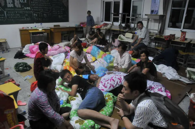 People stay at a school classroom after a tornado hit Yancheng, Jiangsu province, China, June 24, 2016. (Photo by Reuters/Stringer)