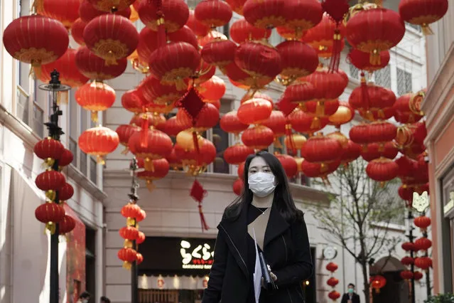 A woman wearing mask, walks on a street in Hong Kong, Thursday, February 20, 2020. More than 100 Hong Kong passengers from the virus-hit cruise ship Diamond Princess arrived home from Japan early Thursday on a Cathay Pacific plane chartered by the Hong Kong government. (Photo by Kin Cheung/AP Photo)