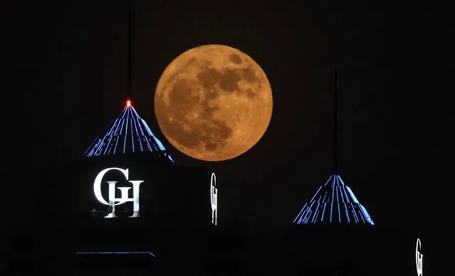 The full “Buck” super moon, rises behind the Dubai Marina in the Gulf emirate of Dubai, on July 13, 2022. (Photo by Giuseppe Cacace/AFP Photo)
